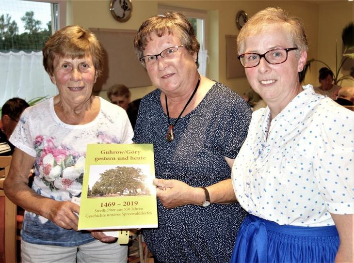 Bürgermeisterin Kerstin Jaser (r.), Erna Koppermann (m.) und Redakteurin Edeltraud Radochla (l.) präsentieren gemeinsam die Festbroschüre, die anlässlich des 550. Jahrestages der urkundlichen Ersterwähnung von Guhrow erschienen ist.