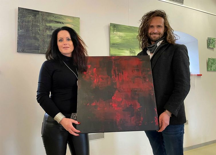 Die Cottbuser Malerin "Holly" und Steinitzhof-Verantwortlicher Marco Wentworth mit einem der Werke, die nun im Kultur- und Informationszentrum der Stadt Drebkau ausgestellt werden.