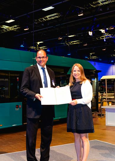 Geschäftsführer Ralf Thalmann (l.) nimmt den Förderbescheid aus den Händen der Parlamentarischen Staatssekretärin beim Bundesminister für Digitales und Verkehr Daniela Kluckert entgegen.