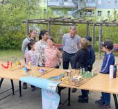 Roland Ledwa, Geschäftsführer der Wohnungsgesellschaft Riesa, lässt sich von den Kindern der Grundschule und Kita ihre kreativen Modelle für einen neuen Spielplatz erklären.