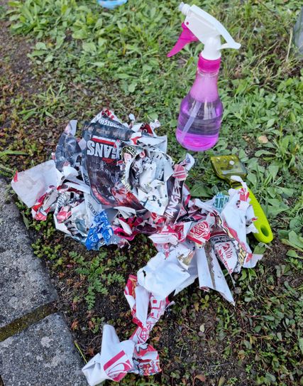 Freiwillige entfernen Hass-Aufkleber im Burger Ortsbild.