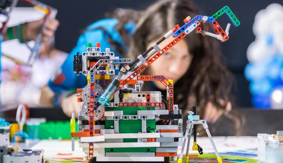 Eine Schülerin begutachtet ihren Roboter