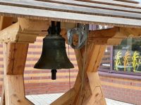Holzbildhauer Hans-Georg Wagner spricht im Raum der Stille über dieses besondere Projekt. Für die kleine Glocke wurde ein neuer Glockenstuhl gefertigt. Dieser steht unweit der Kantine des Krankenhauses.