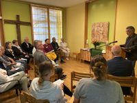Holzbildhauer Hans-Georg Wagner spricht im Raum der Stille über dieses besondere Projekt. Für die kleine Glocke wurde ein neuer Glockenstuhl gefertigt. Dieser steht unweit der Kantine des Krankenhauses.