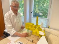 Geschäftsführer Jörg Schaldach am selbstgebauten Modell des Krematoriums mit einen Entwicklungsstufen.