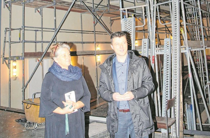 Theaterchefin Ann-Kristin Böhme und Bürgermeister Markus Renner stehen im Bühnenhaus, dass den Blick auf die Gerüste im  Zuschauerraum freigibt.