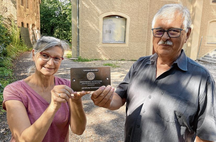 Ina Heß von der Bürgerstiftung Meißen und Ortskurator Dr. Reinhard Plüschke präsentieren die Bronzetafel, die künftig an der Jahnhalle von der wertvollen Zusammenarbeit und der großen finanziellen Unterstützung der Deutschen Stiftung Denkmalschutz zeugt.