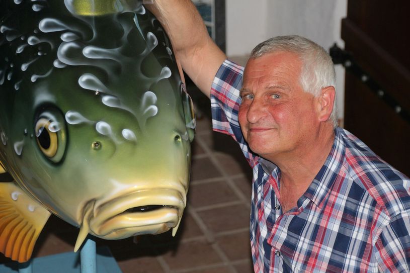 Dietrich Kunkel, 1. Vorsitzender vom Förderverein Hüttenwerk Peitz, mit der Karpfenskulptur, die bereits 2009 für Werbezwecke angeschafft wurde. Foto: jho