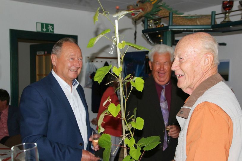 Michael Hampsch (l.) bekommt für den Ruhestand von seinem früheren Deutschlehrer und späteren Kollegen Werner Zanotti (r.) eine besonders resistente und selbst gezogene Rotweinrebe. Sein ehemaliger Kollege Gerhard Göttlich freut sich auch. Foto: Farrar