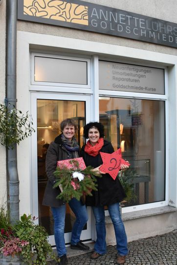 Goldschmiedin Annette Lührs (l.) und Nadine Wollrad vom Bürgwertreff samt Geschenk und Türchennummer. Foto: privat