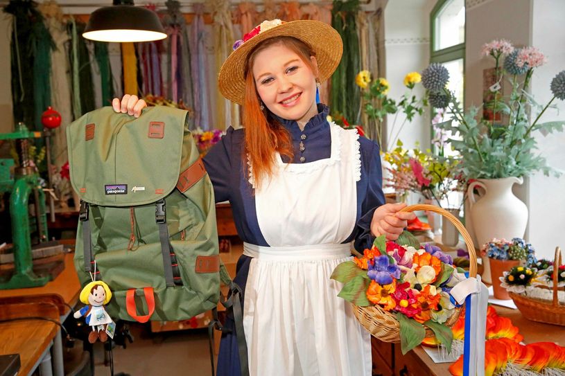 Das Sebnitzer Blumenmädchen Doreen Berger zeigt den grünen Wanderrucksack. Da passt wirklich allerhand hinein.    Foto: PR/TVSSW