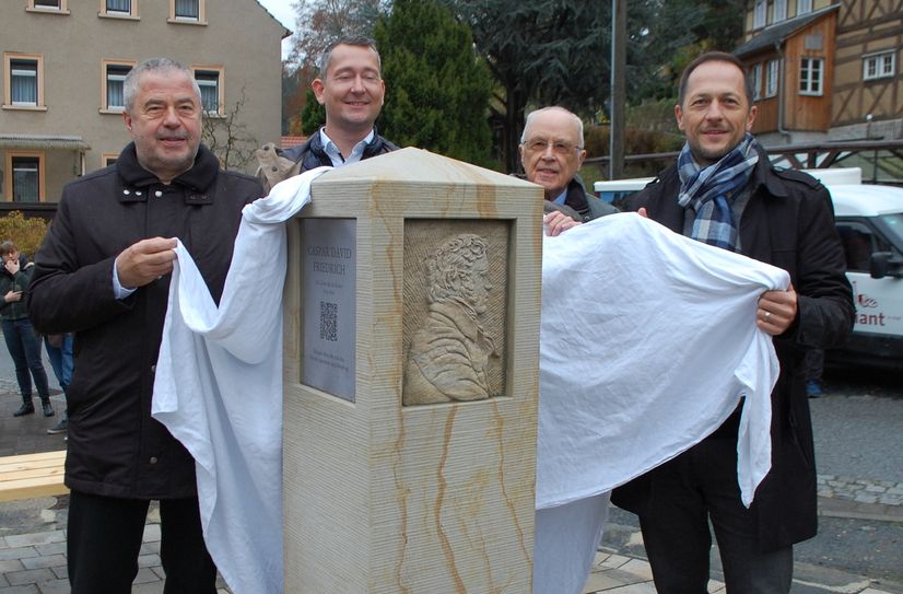 Landrat Michael Geisler, Felix Zschoge, Gerd Englick und Bad Schandaus Bürgermeister Thomas Kunack (v.l.n.r.) bei der Enthüllung der Sandsteinstele zu Ehren Caspar David Friedrichs.