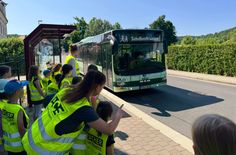 Das sichere Warten an der Bushaltestelle an der Grundschule wird eingeübt.