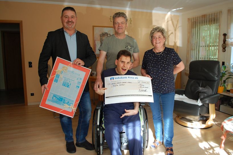 Der stellvertretende Verlagsleiter des WochenKuriers, Peter Hatzirakleos (li.), übergibt den Spendenscheck und eine Druckplatte der Zeitung mit dem Spendenaufruf an Daniel Näther und seine Familie.