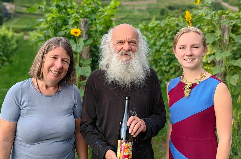 v.l. Barbara Plänitz, Vorsitzende des Fördervereins, der Künstler Klaus Liebscher und die Sächsische Weinkönigin Alona Chesnok im Weingut Aust mit einer Flasche der diesjährigen Sammler-Edition.