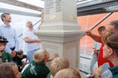 Steinmetzmeister Volker Maaz und Museumsleiter Stefan Auert-Watzik erläutern Oberbürgermeister Ronald Kretzschmar und einigen Hortkindern die historische Funktionsweise der Postmeilensäule.