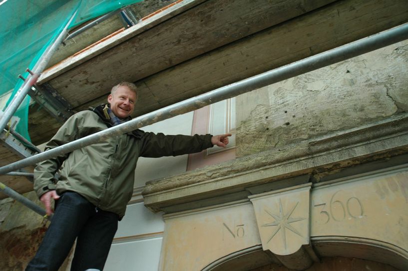 Diplom-Restaurator Markus Schulz verweist auf die freigelegten Farbbefunde an der Fassade.               Foto: Wo