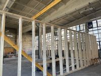 Kunstglaser Christoph Graefe zeigt Anja Dietel wie genial und einfach schon damals der Klappmenchanismus für die Fenster erdacht wurde. Im Inneren der Halle werden die festen Ausstellungswände installiert. Für die Deckensanierung kam eine Hebebühne zum Einsatz.  Fotos: Farrar