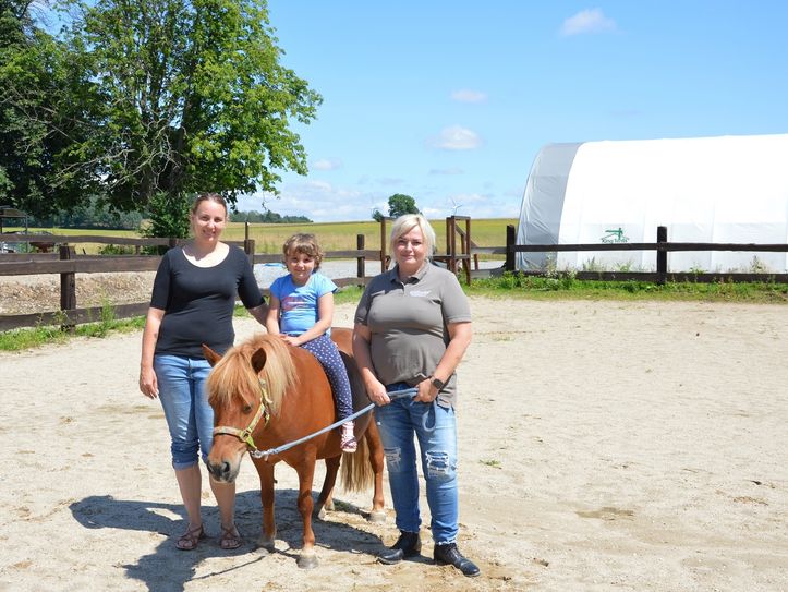 Tessa mit Pony Polly und Mama sowie Reittherapeutin Nicole Wieberneit (r.). Foto: Sonnenstrahl e.V.