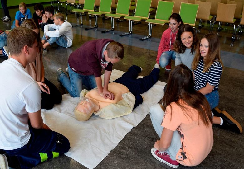 Jan Krannich (l.), Auszubildender zum Notfallsanitäter bei der Cottbuser Berufsfeuerwehr, leitet Schüler des Steenbeck-Gymnasiums bei der Herz-Druck-Massage an. Foto: CTK