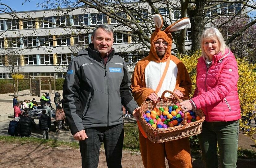 Vonovia Regionalleiter Kai-Michael Sigmund (li.) übergibt, gemeinsam mit dem Osterhasen, einen Korb gefüllt mit bunten Ostereiern, an die Hortlleiterin, Regina Gableske.