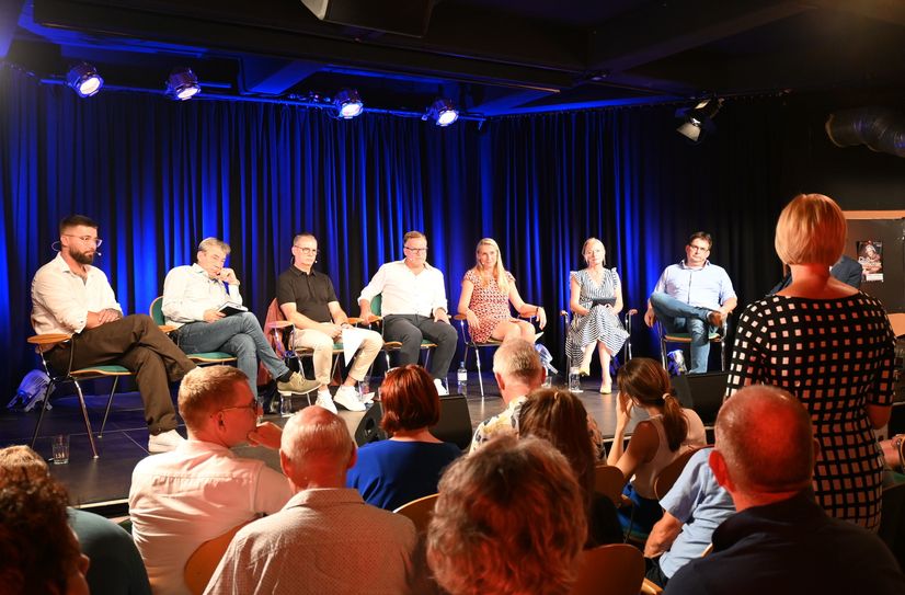 Moderator Philipp Wagner, die OB-Kandidaten Tim Lochner, Ralf Thiele, André Liebscher, Kathrin Dollinger-Knuth, Moderatorin Carmen Andres und Kandidat Ralf Wätzig reagieren auf Publikumsfragen.