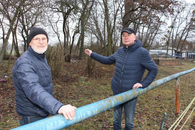 Direkt hinter der ehemaligen Tribüne (rechts zu sehen) soll der Kletterfelsen auf dem Sportplatz in Sedlitz entstehen. Michael Vetter (li.) und Ulrich Hoika (re.) aus dem Sedlitzer Bergfreunde e.V. freuen sich darauf.