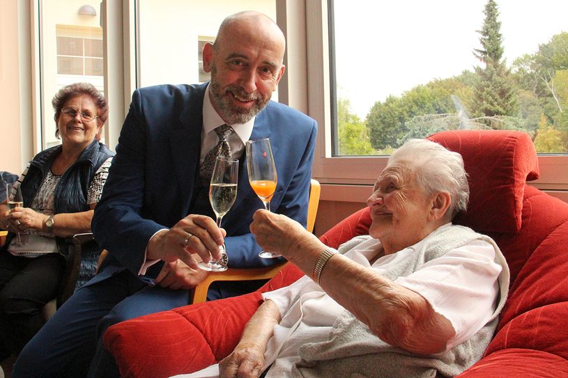 Die Jubilarin hat es sich in einem Lehnsessel gemütlich gemacht und genießt ihre Geburtstagsfeier mit einem Glas Multivitaminsaft. (Foto: André Wucht, Stadtverwaltung Bautzen)