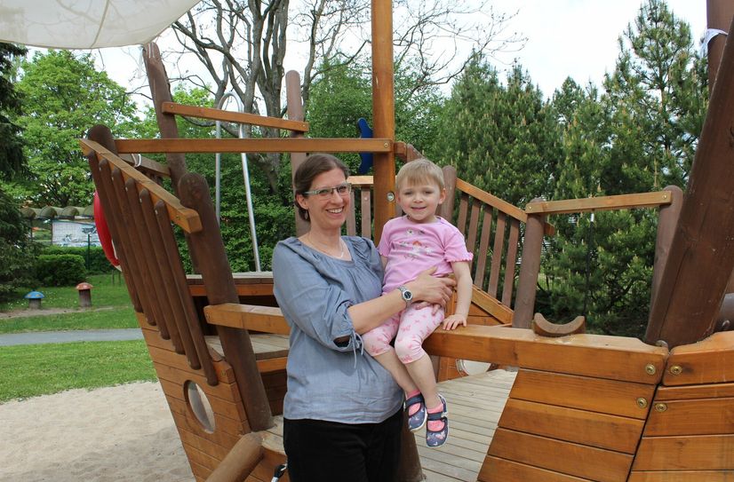 Kitaleiterin Beatrice Grund und die kleine Katja vor dem neuen Spielschiff.