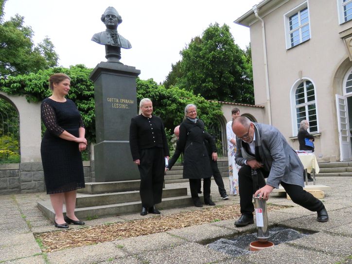 Oberbürgermeister Roland Dantz versenkt im Beisein der Geschäftsbereichsleiterin des Staatsministeriums für Kultur und Tourismus, Franziska Brech, der Architektin Katrin Leers-Kulka sowie der Leiterin der Städtischen Sammlungen Kamenz, Dr. Sylke Kaufmann, die Zeitkapsel zur Grundsteinlegung (v.l.n.r.).
