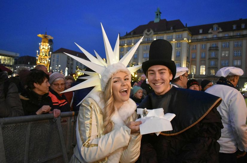 Linda Jung als Herrnhuter Sternenmädchen und Pflaumentoffel helfen bei der Verteilung des Stollens.