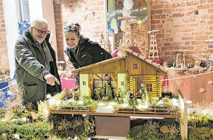 Pater Alois und Pia Wenning zeigen Motive der Krippenausstellung.