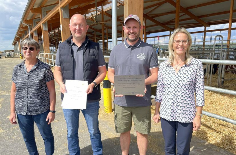 Die neue Stalltafel mit der Auszeichnung "tiergerechte und umweltverträglich Haltung 2021/2022 in Sachsen" wird künftig auf dem Milchhof von Marko und Torsten Schlunke in Diera angebracht sein. Übergeben haben diese Ehrung die Referatsleiterin tierische Erzeugnisse im  Staatsministerium, Annett Bugner (r.) und Jutta Bennewitz vom Bauernverband und Vorstand der Sächsischen Milcherzeugergenossenschaft Quersa eG.