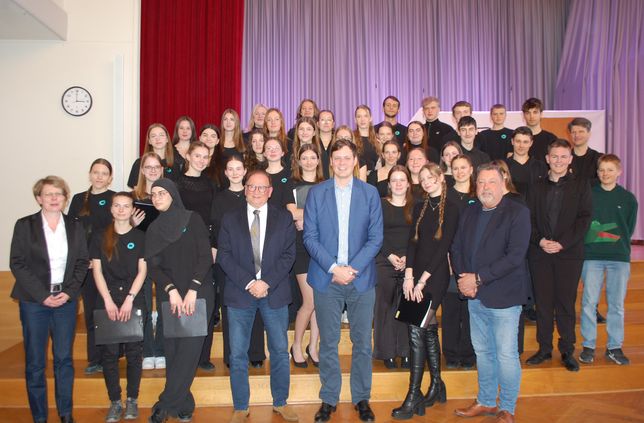Sachsens Kultusminister Conrad Clemens (5. v. li.) bei seinem Besuch am Pestalozzi-Gymnasium Heidenau mit Schulleiter Erik Richter (re.) und dem Schulchor. Mit dabei waren auch Heidenaus Bürgermeister Jürgen Opitz (4. v. li.) und die stellvertretende Bürgermeisterin Marion Franz (li.).
