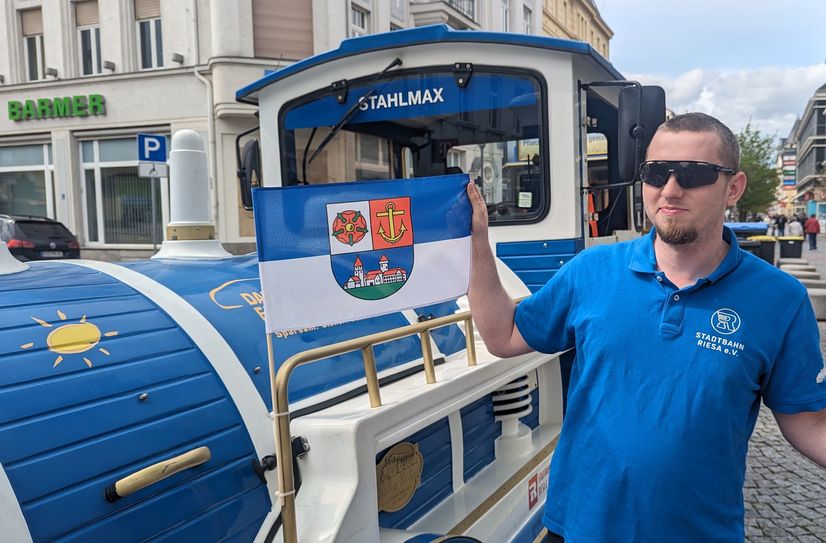 Fahrer und Vorstandmitglied Patrick Mensing zeigt die neue Riesa-Flagge an der Stadtbahn.