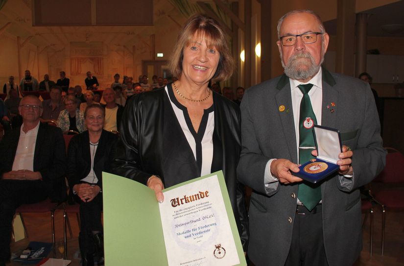 Heidrun Lukas (li.), Vorstandsvorsitzende des KSB OSL, wurde von Kreisschützenmeister Lothar Engler (re.) mit der Medaille für Förderung und Verdienste in Gold des Brandenburgischen Schützenbundes überrascht.