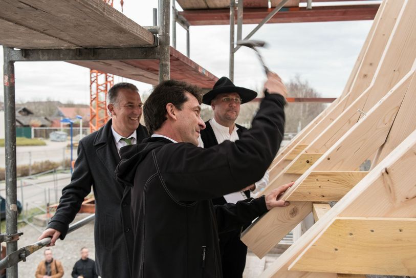 Den symbolischen letzten Nagel schlagen Spreewelten-Geschäftsführer Michael Jakobs (links im Bild) und Prokurist Axel Kopsch (Mitte, mit dem Hammer in der Hand) unter dem prüfenden Blick von Zimmerer-Meister René Nousch ein. Foto: Spreewelten GmbH