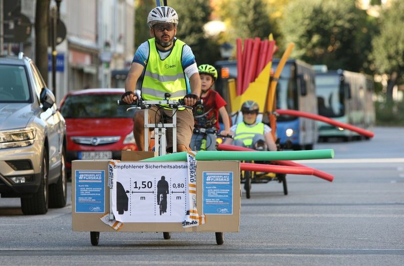 Mit Poolnudeln machen Akteure vom ADFC auf den mangelnden Sicherheitsabstand im Straßenverkehr aufmerksam.