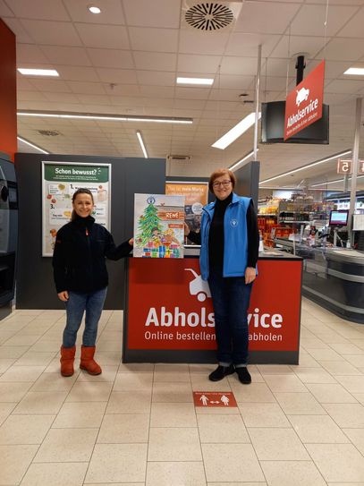 Heidi Kempke (re.) vom Deutschen Kinderschutzbund e.V., Ortsverband Senftenberg, überreicht Kerstin Radke (li.) vom Rewe-Markt in Senftenberg ein Aquarell. Das Motiv fasst die gemeinsame Weihnachtsaktion zusammen und ist ein Dank für die gute Zusammenarbeit.