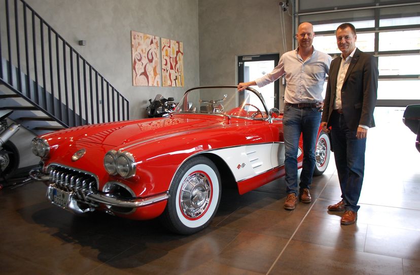 V8 Werk-Geschäftsführer Christoph Herbrig und Bundestagsabgeordneter Torsten Herbst (v.l.n.r.) vor einer roten Corvette C1 im Ausstellungsraum des Pirnaer V8-Werks.