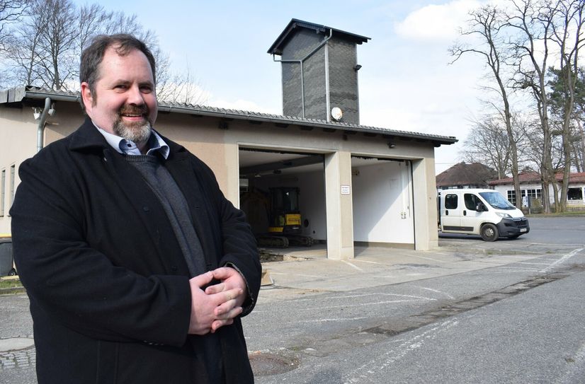 Bürgermeister Hardy Glausch steht vor dem Feuerwehrgerätehaus in Crosta, das derzeit umgebaut wird.