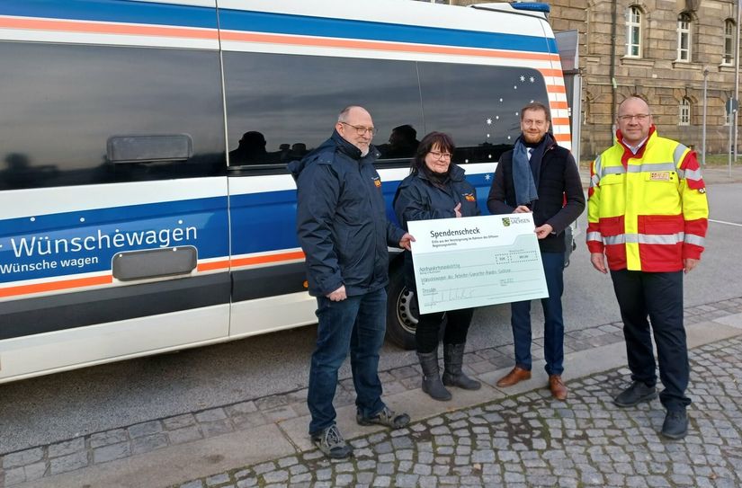 Michael Kretschmer mit ASB-Landesgeschäftsführer Stefan Mette und den zwei ehrenamtlichen Wunscherfüllern Karsten Queitzsch und Jaqueline Baumgarten vom ASB-Wünschewagen Sachsen.