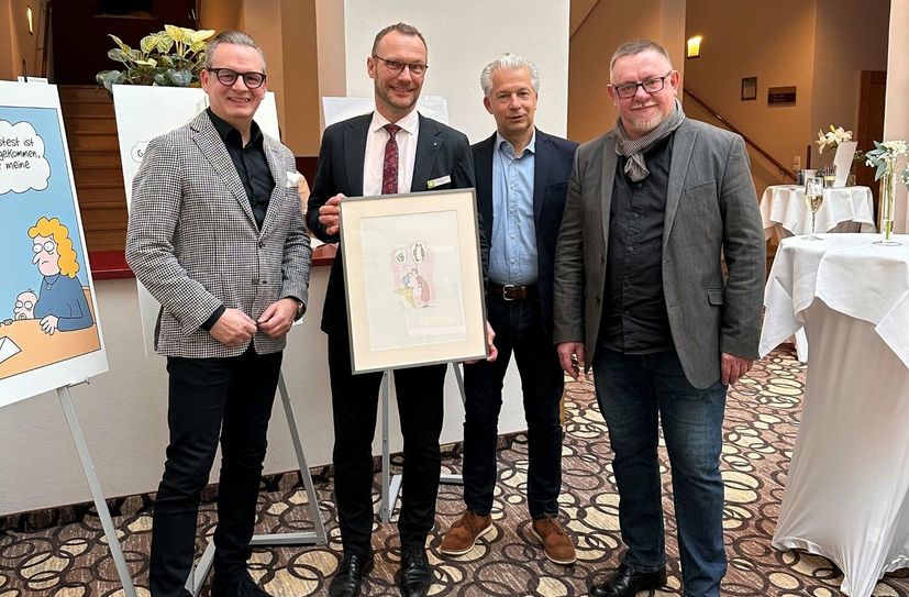 Mario Süßenguth (re.) und Peter Ufer (3.v.li.) überreichen Ralf Thiele (li.), Geschäftsführer der Pura Hotels und Hoteldirektor Markus Gorny (2.v.li.) ein handsigniertes Blatt von Axel Bierwolfs »Liebesträume«.