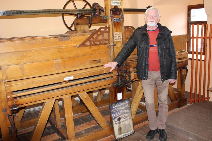 Frank Baumert an seinem »alten Mädchen«, einer historischen Kaltmangel, die er liebevoll wieder aufgebaut und in Betrieb genommen hat.
