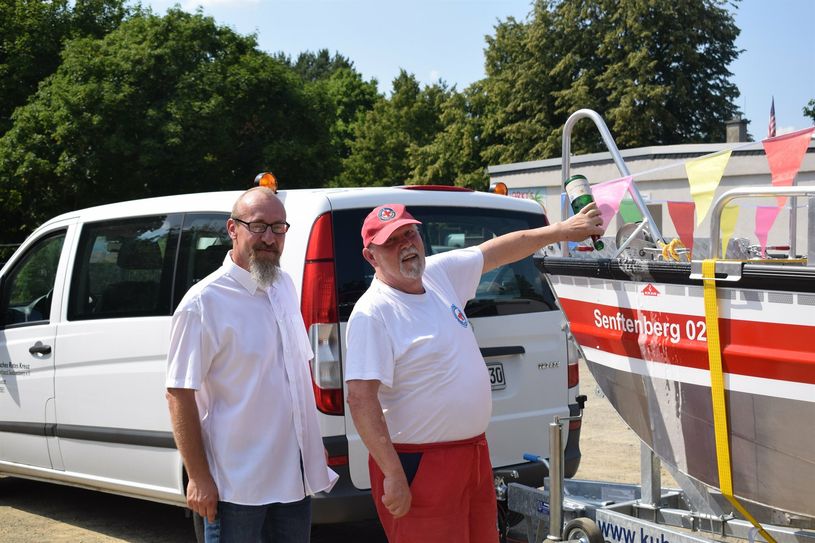 Jörn-Torsten Kusch (stellv. Ortsgruppenleiter) und Gerhard Kaergel  (Ehrenmitglied der Ortsgruppenleitung) taufen die »Senftenberg 02« ganz traditionell mit einer Flasche Sekt.