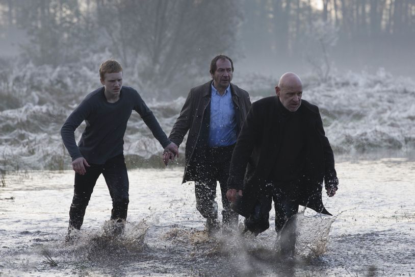 „Spreewaldkrimi - Die Sturmnacht“: Peter Fähnrich (Sammy Scheuritzel), Fichte (Thorsten Merten) und Kommissar Krüger (Christian Redl) laufen durch ein überflutetes Feld. Foto: ZDF/Oliver Vaccaro