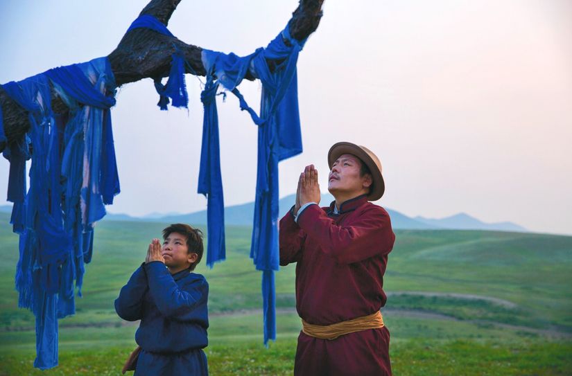 Szene aus »Die Adern der Welt«: Amra (Bat-Ireedui Batmunkhw) und Erdene (Yalalt Namsrai) beten am Baum.