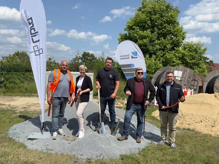 Mirza Corovic, Bauleiter von Libra GmbH, Kathleen Wilken, Amtsdirektorin des Amtes Schradenland, Jasmin Mehovic, Projektleiter von Libra GmbH, Alf Richter, Leiter Bau- und Ordnungsamt des Amtes Schradenland, Rick Klemm, Point of Sales Manager von Deutsche Glasfaser (v.l.n.r.), beim ersten Spatenstich für den Glasfaserausbau in Großthiemig.