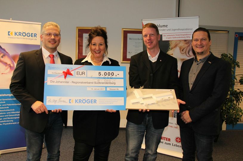 Der Spendenscheck über 6.000 Euro ist übergeben (v.li.n.re.): Matthias Rudolf (Regionalvorstand der Johanniter Südbrandenburg), Petra Kröger-Schumann (Geschäftsinhaberin der Medizintechnik & Sanitätshaus Harald Kröger GmbH), Roland Hauke (Projektleiter Kinderhaus „Pusteblume“) und Michael Städter (Mitglied der Geschäftsführung in der Medizintechnik & Sanitätshaus Harald Kröger GmbH). Foto: sts