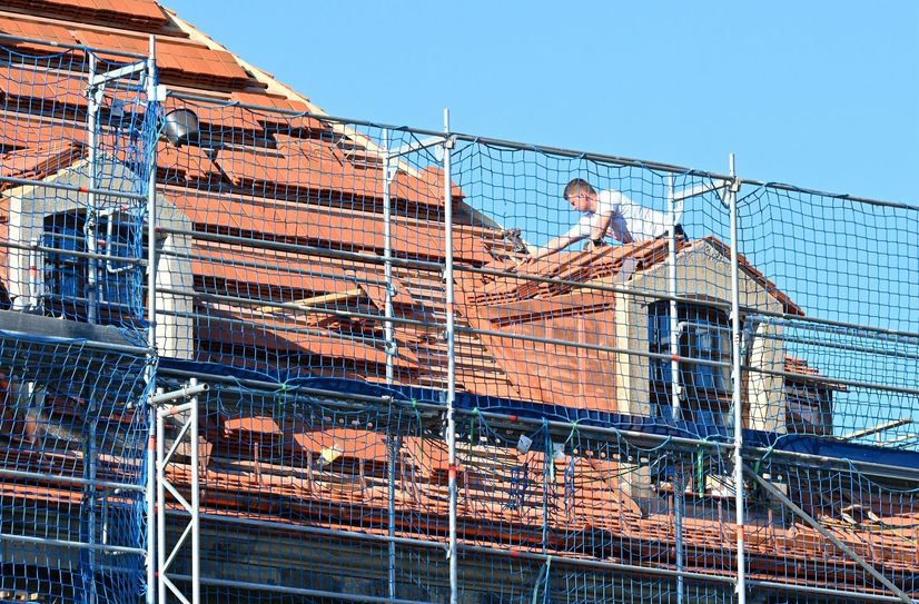 Dachdecker auf dem Dach des Blockhauses.